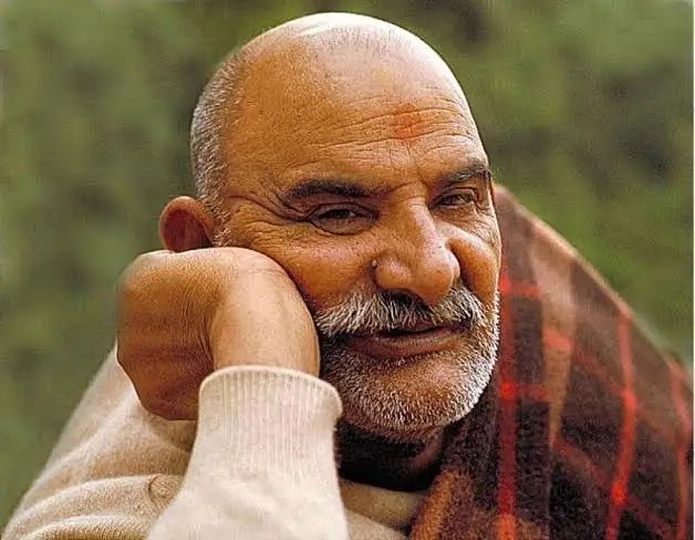 Neem Karoli Baba, affectionately known as Maharaj-ji, resting with a plaid blanket over his shoulder
